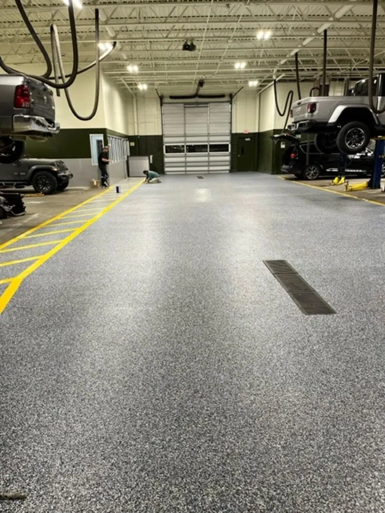 Auto shop floor with grey flake epoxy and a yellow safety line