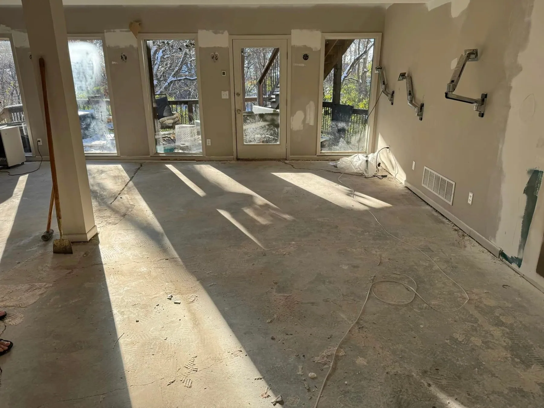 Bare, stained concrete floor in a room with french doors