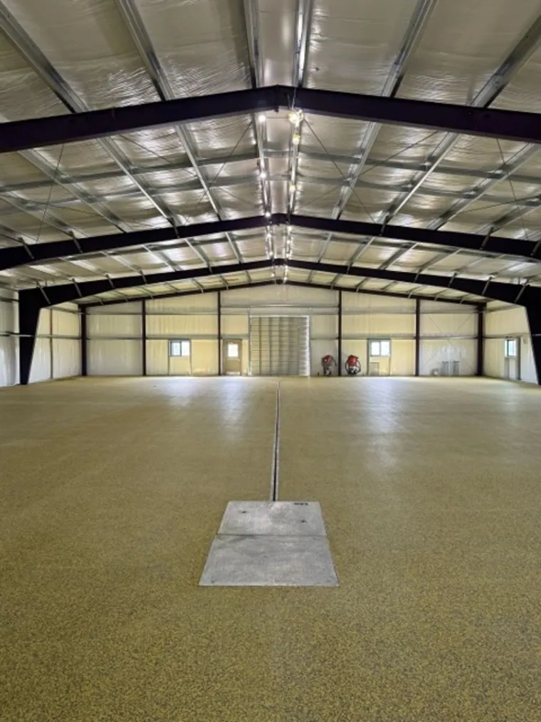 Gold and tan flake floor across a large steel building