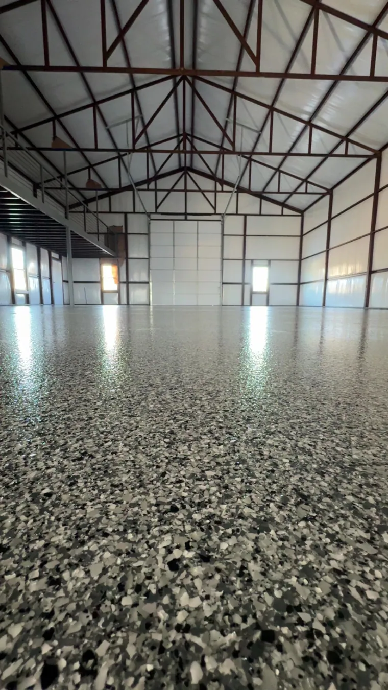 Grey flake floor filling a large steel-framed barn
