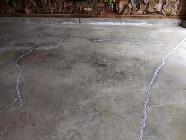 Badly cracked bare concrete floor before repair