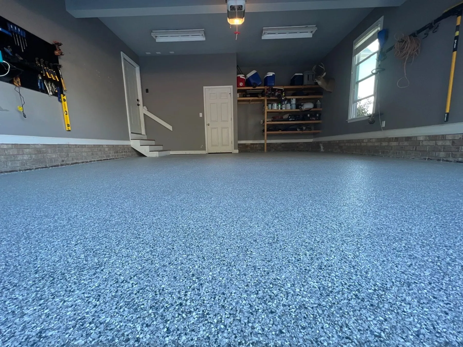 Residential garage finished with a blue and grey full-flake epoxy floor