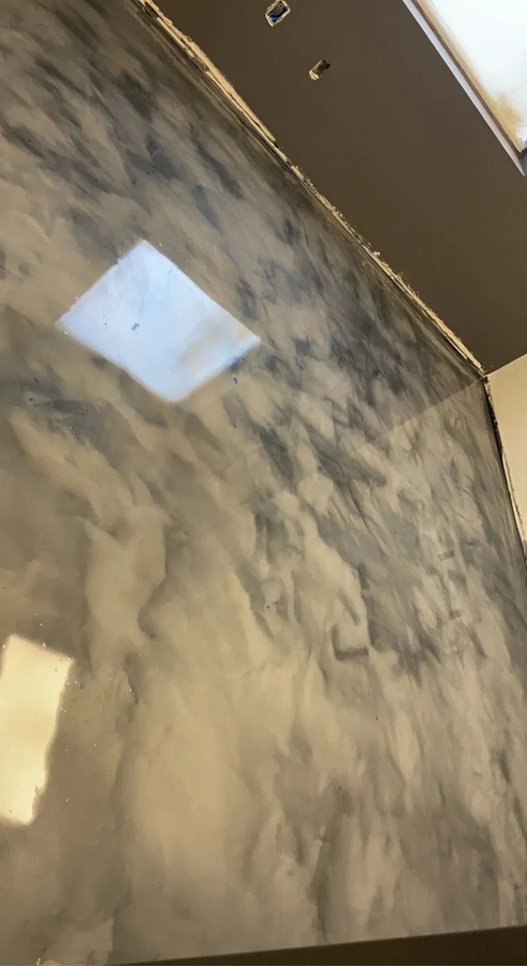 Cream and tan metallic epoxy floor with a skylight reflection